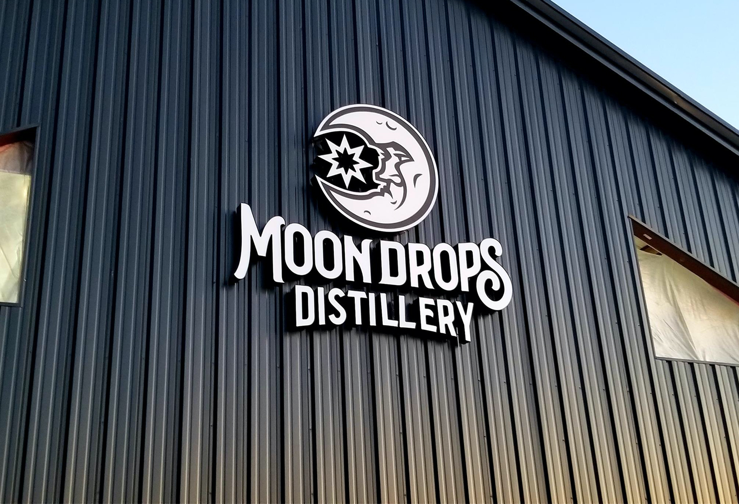 The logo of the Moon Drops Distillery company on the wall of the building